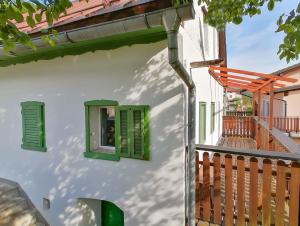 a building with green windows and a balcony at počitniška hiška MEDVEJKE in Slap ob Idrijci