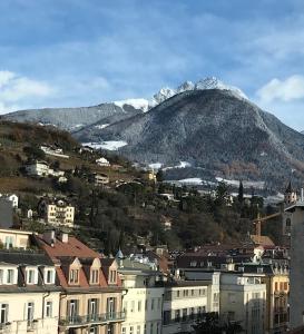 una città con una montagna sullo sfondo con edifici di Theatre Lodge Attico teatro a Merano