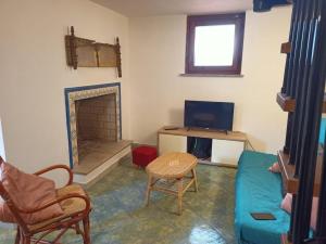 een woonkamer met een bank en een open haard bij Casa blu Arbatax con giardino e terrazza in Tortolì