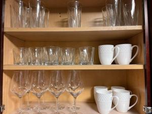 a bunch of wine glasses sitting on a shelf at Gorgeous Williamsville Home in Central Location in Buffalo +18 photos
