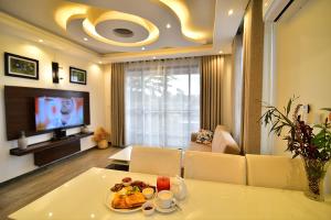 a living room with a table with a plate of food on it at ENTEBBE STAY Apart-Hotel in Entebbe