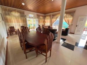 a dining room with a wooden table and chairs at European B & B Hotel in Bandarawela