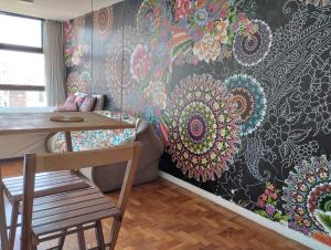 a living room with a wall with a floral wallpaper at Mirante do Vale - Centro Histórico de São Paulo in Sao Paulo