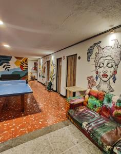 Habitación con sofá y mesa de ping pong. en Zamia Hostel, en Bucaramanga