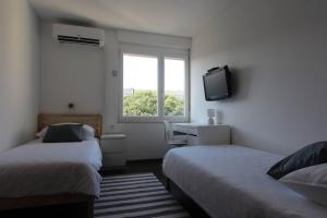 斯普利特的住宿－Zebrus apartment，一间卧室设有两张床、一台电视和一扇窗户。
