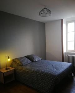 a bedroom with a bed and a lamp and a window at Chambre cosy de Bonabry in Fougères