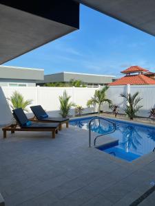 a patio with two lounge chairs and a swimming pool at Casa Gravel in Pochote