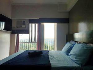 a bedroom with a bed with a large window at 1649 Tagaytay Staycation by Jordy in Tagaytay