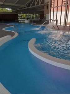 ein großer Pool mit blauem Wasser in einem Gebäude in der Unterkunft Charmante maison in Vitry-le-François