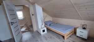 a small bedroom with a bed in a attic at Domek Viking in Gródek Nad Dunajcem