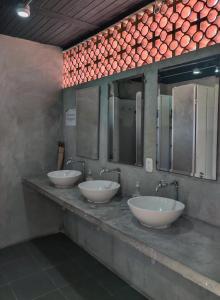 a row of four sinks in a public bathroom at Zamia Hostel in Bucaramanga