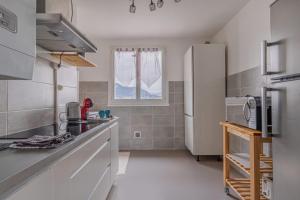 uma cozinha com um frigorífico branco e uma janela em Le cocon em Fontaine