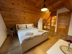 a bedroom with a bed in a wooden ceiling at Alma Apartmanház in Harkány