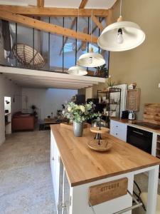 a kitchen with a wooden counter with flowers on it at Le Mas du Castellas 5* in Le Thor