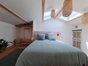 a bedroom with a large bed with blue pillows at Le Mas du Castellas 5* in Le Thor