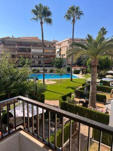 een uitzicht op een resort met een zwembad en palmbomen bij Bungalow con jardin y piscina cerca de la playa in Oropesa del Mar