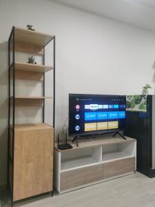 a flat screen tv sitting on top of a entertainment center at Cozy room, BKK for short and long term rentals, 10mins walk to BTS, 25mins taxi to DMK airport in Ban Ko