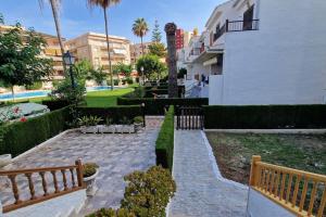 een tuin met twee banken en een gebouw bij Bungalow con jardin y piscina cerca de la playa in Oropesa del Mar