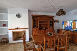 een eetkamer met een tafel en een tv bij Bungalow con jardin y piscina cerca de la playa in Oropesa del Mar