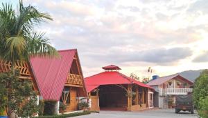 a house with a red roof and a palm tree at Cabañas Amalú in San Agustín