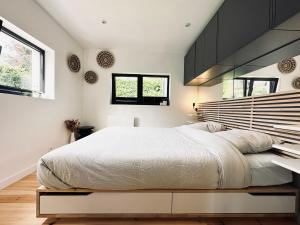 1 dormitorio con 1 cama blanca grande y armarios negros en La Suite (Ô) Wood & Chic, en Cucq