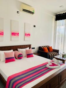 坦加拉的住宿－Kalametiya Bird Villa，一间卧室配有一张带色彩缤纷枕头的大床