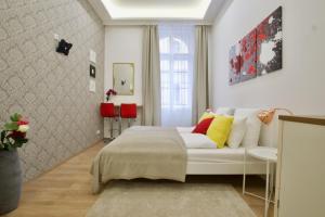 Un dormitorio con una cama blanca con almohadas amarillas y rojas en St. King 11 Apartments en Budapest