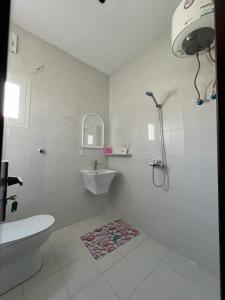 La salle de bains blanche est pourvue d'un lavabo et de toilettes. dans l'établissement مشتى الجنوب ( دخول ذكي ), à Salhabah