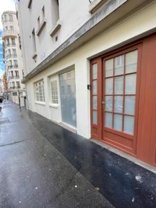ein Gebäude mit roten Türen an der Straßenseite in der Unterkunft Paris Maurice Nordmann superbe 2 pièces in Paris