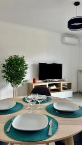 a table with plates and wine glasses and a television at Menton centre, jardin Bioves, casino in Menton