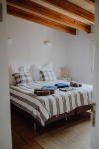 a bed with blankets and pillows on it in a room at Finca S'Agret in Capdepera