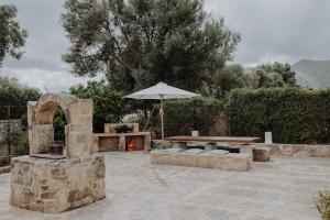 a patio with a table and an umbrella at Finca S'Agret in Capdepera
