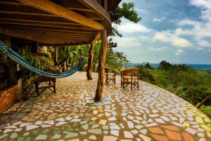 une terrasse avec des chaises et un hamac dans une maison dans l'établissement Cabañas Cochapunko I Espectacular vista 360, à Ayampe