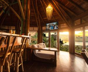 une salle à manger avec une table et une télévision dans une maison dans l'établissement Cabañas Cochapunko I Espectacular vista 360, à Ayampe