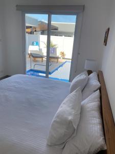 um quarto com uma cama branca e vista para a piscina em Casa Gravel em Pochote