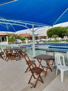 a group of tables and chairs under a blue umbrella at Paulo Afonso BA Capitalbda Energia e do turismo in Paulo Afonso