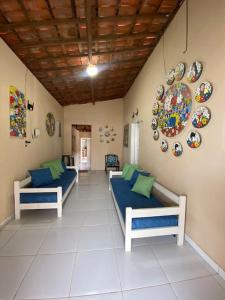 a room with two beds and plates on the wall at Paz, arte, beleza e natureza na praia de Sagi in Baía Formosa