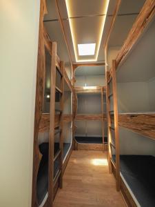 przedpokój z drewnianymi łóżkami piętrowymi w pokoju w obiekcie Sleeptrailer w Zurychu