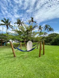 a playground with a hammock and a rock and palm trees at Porto Grande Hotel & Convention in São Sebastião