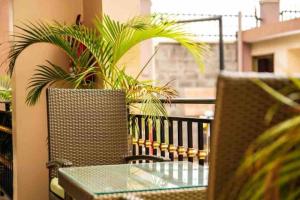 uma mesa e cadeiras numa varanda com uma planta em Studio Furnished Apartment Entebbe em Entebbe