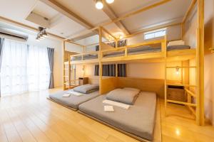 two bunk beds in a room with wooden floors at HAN'S EBISU - Shibuya - Entire House for Max 10 ppl in Tokyo