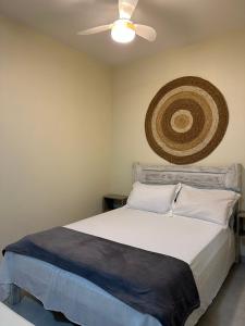 a bedroom with a bed with a ceiling fan at Apartamento na praia Garopaba San Pietro Sc loft 102 in Garopaba +3 photos