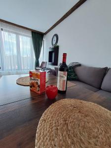 Premium Apartment in Borovets Gardens Complex في بوروفتس: زجاجة من النبيذ موضوعة على طاولة في غرفة المعيشة