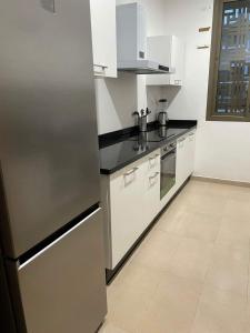 una cucina con armadi bianchi e frigorifero in acciaio inossidabile di Appartement a la marina de salé a Salé