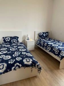um quarto com 2 camas com lençóis azuis e brancos em Appartement a la marina de salé em Salé