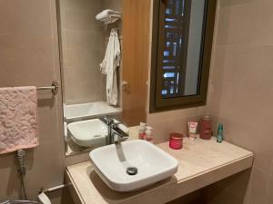 a bathroom with a white sink and a mirror at Appartement a la marina de salé in Salé