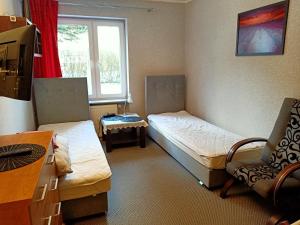 ein kleines Zimmer mit 2 Betten und einem Stuhl in der Unterkunft Bukowy zakątek kwatera prywatna in Koszalin