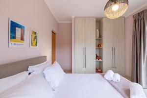 1 dormitorio con 1 cama blanca grande con almohadas blancas en Mnḗmē, en Asíni