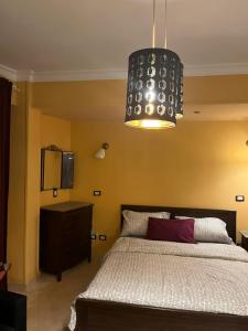 a bedroom with a bed and a chandelier at Heliopolis Rock Residence in Cairo