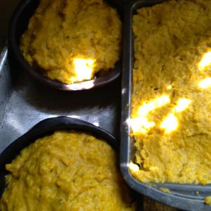 two trays of food sitting on a stove at Hostal Tu'u Koihu in Hanga Roa